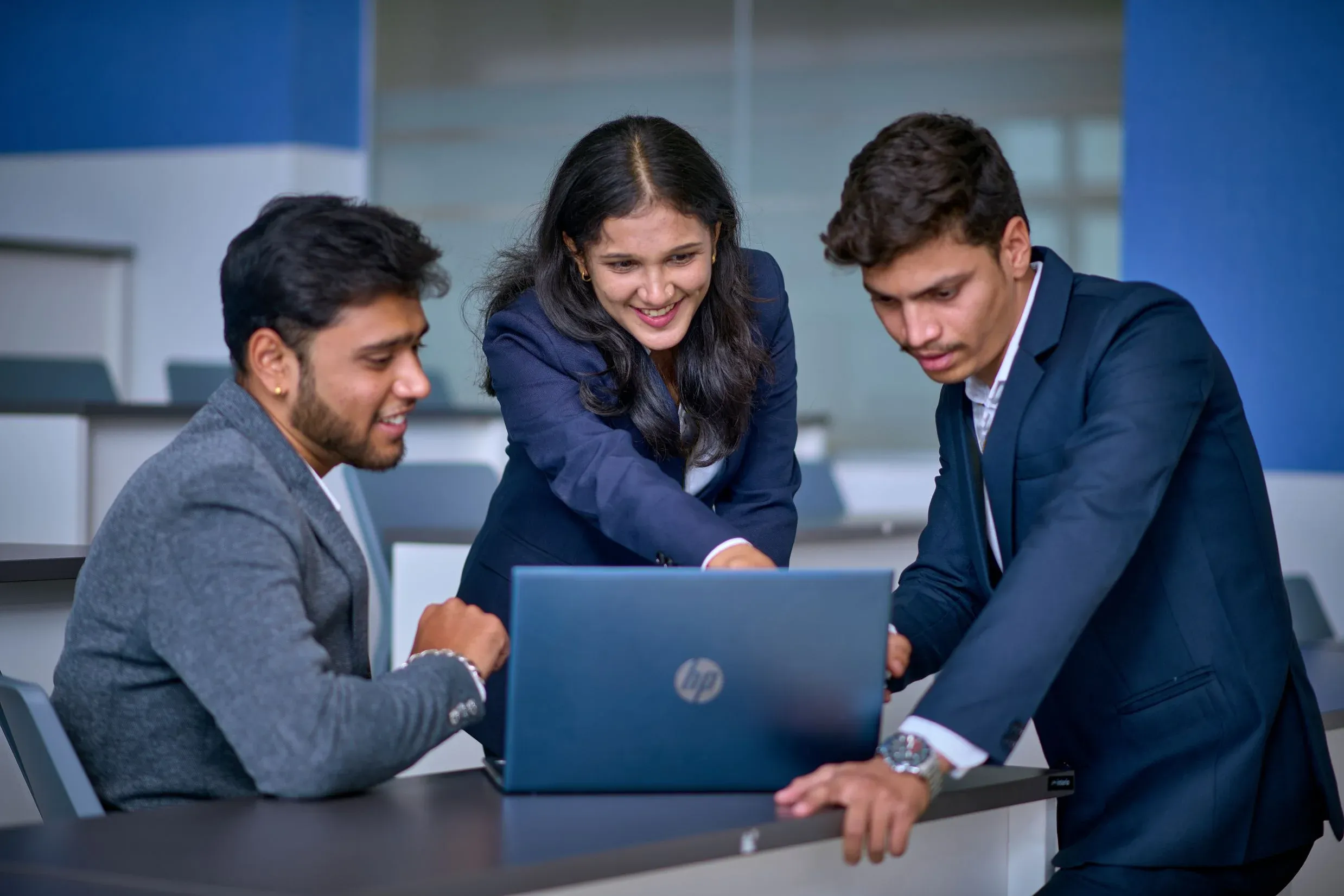Students discussing certain information over a laptop.